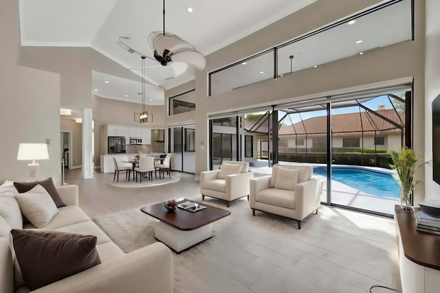 living area with high vaulted ceiling, recessed lighting, and a sunroom