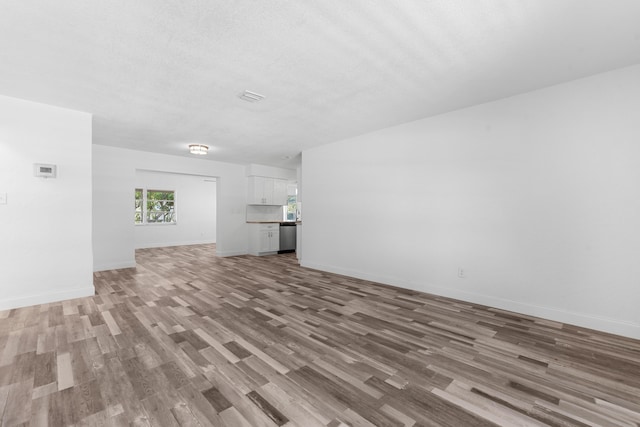 9603 NW 72nd Mnr, Tamarac, FL 33321 - unfurnished living room with baseboards and light wood-style flooring
