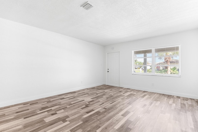 9603 NW 72nd Mnr, Tamarac, FL 33321 - empty room with baseboards, light wood finished floors, a textured ceiling, and visible vents