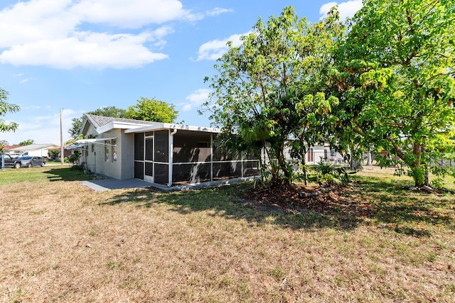 9603 NW 72nd Mnr, Tamarac, FL 33321 - back of property featuring a yard, a sunroom, and stucco siding