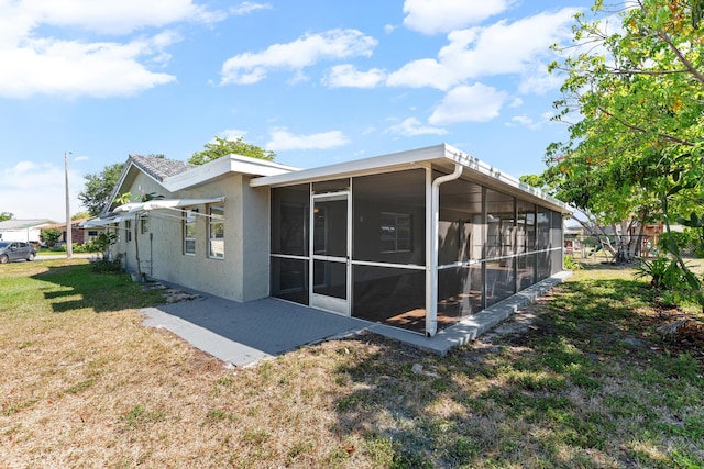 9603 NW 72nd Mnr, Tamarac, FL 33321 - rear view of property featuring a sunroom, stucco siding, and a yard