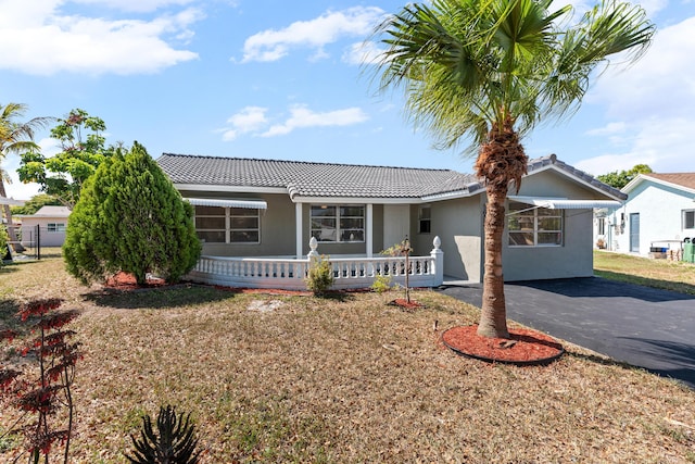 9603 NW 72nd Mnr, Tamarac, FL 33321 - single story home with a tiled roof, a porch, stucco siding, and a front yard