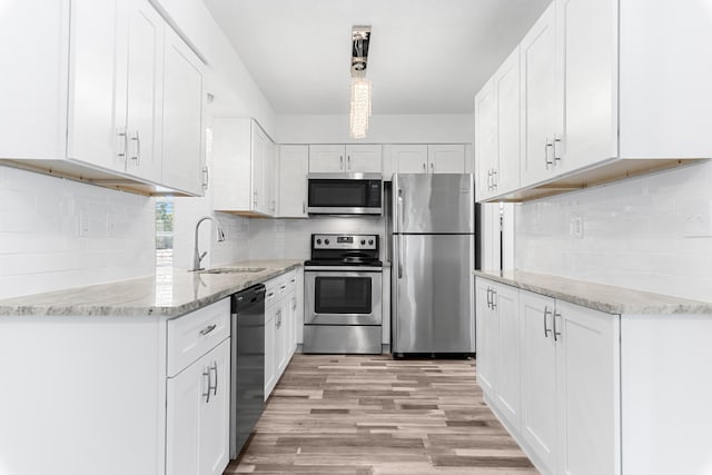9603 NW 72nd Mnr, Tamarac, FL 33321 - kitchen with light stone countertops, white cabinetry, a sink, appliances with stainless steel finishes, and backsplash