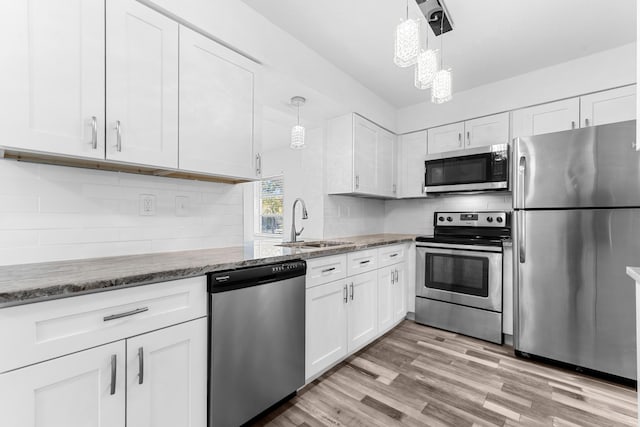 9603 NW 72nd Mnr, Tamarac, FL 33321 - kitchen with appliances with stainless steel finishes, a sink, stone countertops, white cabinetry, and tasteful backsplash