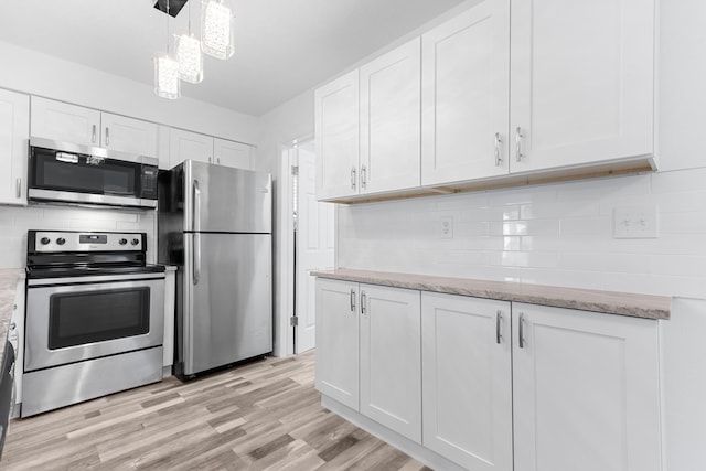 9603 NW 72nd Mnr, Tamarac, FL 33321 - kitchen featuring white cabinets, appliances with stainless steel finishes, decorative backsplash, and light wood finished floors
