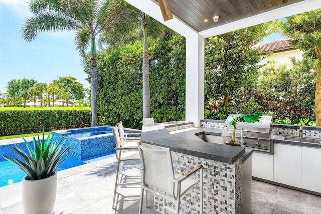 view of patio featuring area for grilling, an in-ground hot tub, and grilling area
