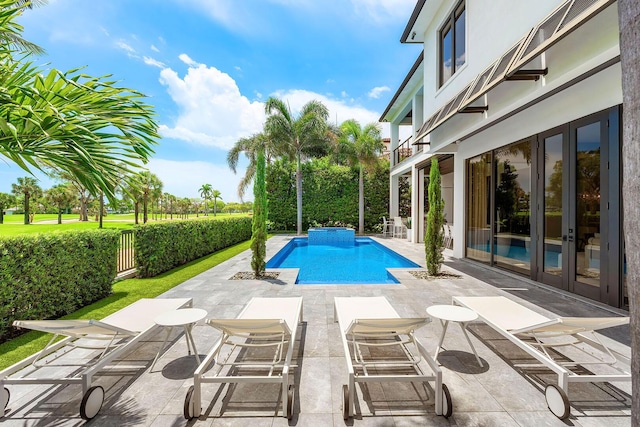 view of pool featuring a patio, a fenced backyard, and french doors