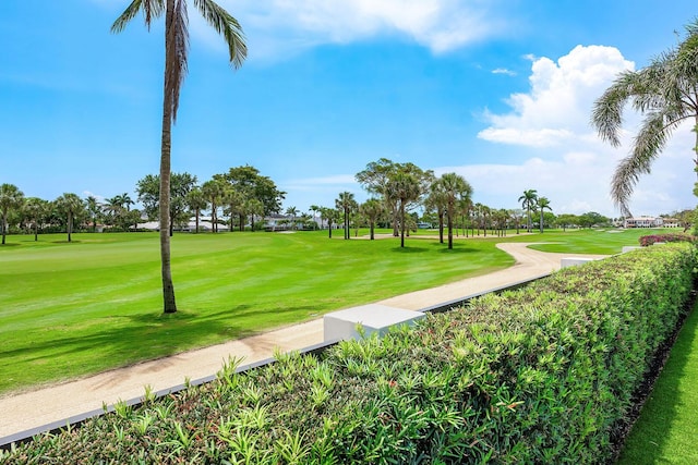 view of community featuring view of golf course and a lawn