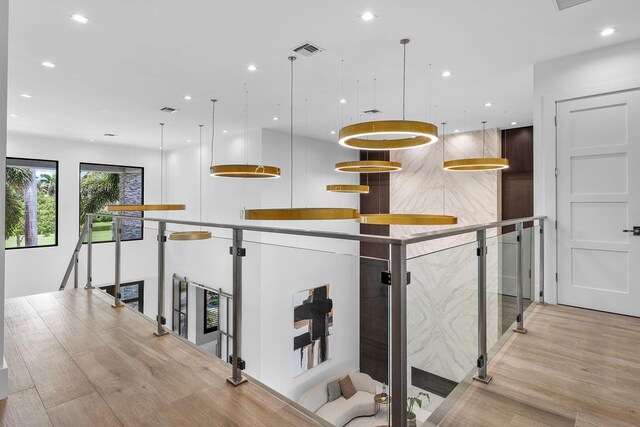 kitchen with recessed lighting, a large island, light wood-style floors, and pendant lighting