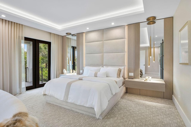 bedroom featuring light colored carpet, access to exterior, recessed lighting, a raised ceiling, and baseboards