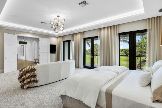 bedroom with french doors, a tray ceiling, access to outside, a chandelier, and recessed lighting