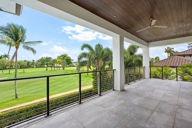 balcony featuring golf course view and a ceiling fan