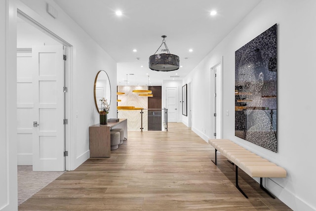 hall featuring light wood-style floors, recessed lighting, and baseboards
