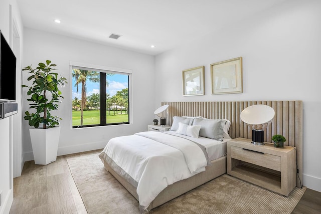 bedroom with wood finished floors, baseboards, and recessed lighting