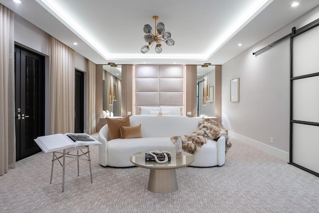 carpeted bedroom with a barn door, baseboards, recessed lighting, and a tray ceiling