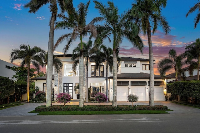 view of front of property with driveway, stucco siding, a garage, and a balcony