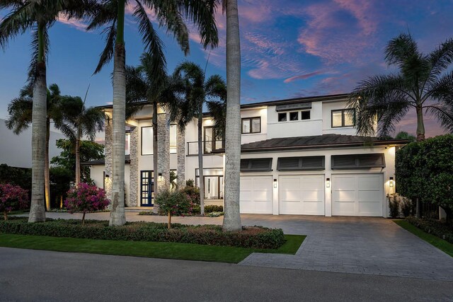 view of front of home with stucco siding, driveway, and an attached garage