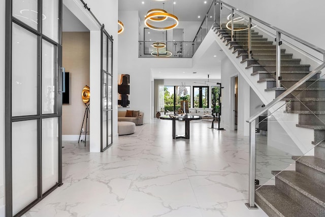 entrance foyer with a high ceiling, french doors, stairs, marble finish flooring, and baseboards