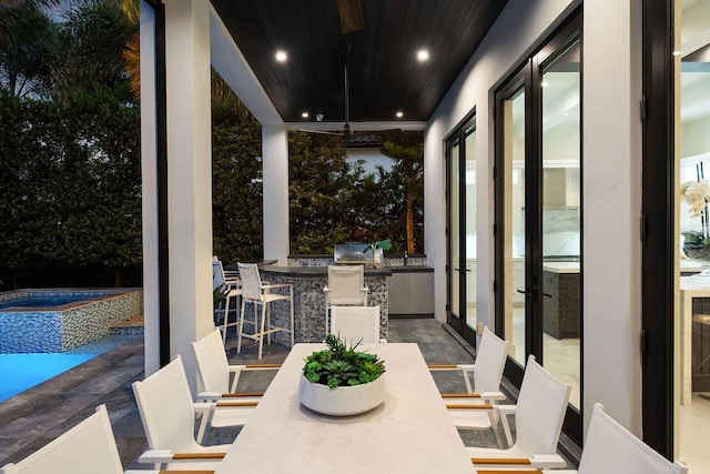 view of patio / terrace with an outdoor kitchen and a pool with connected hot tub