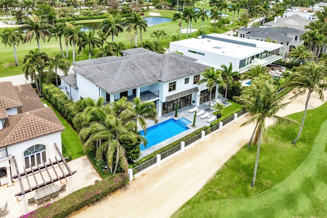 aerial perspective of suburban area featuring a pool, a large body of water, and a golf club