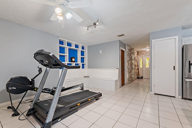 exercise area featuring a ceiling fan, a textured ceiling, and visible vents