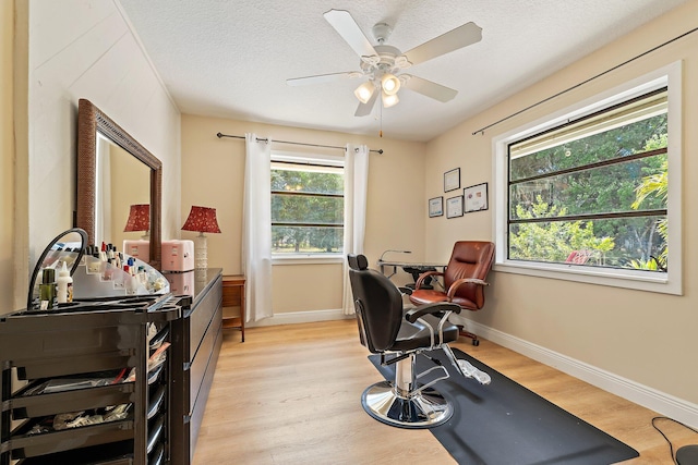 home office with a ceiling fan, baseboards, a textured ceiling, and light wood-style floors