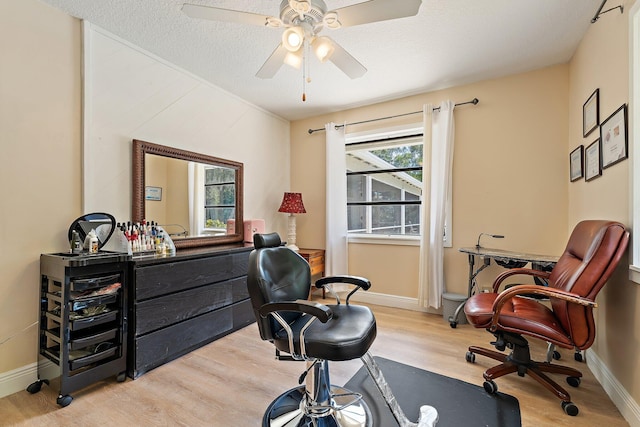 home office with light wood-style floors, baseboards, and a ceiling fan