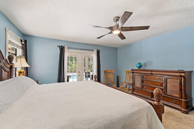 bedroom featuring ceiling fan, french doors, a textured ceiling, access to outside, and carpet