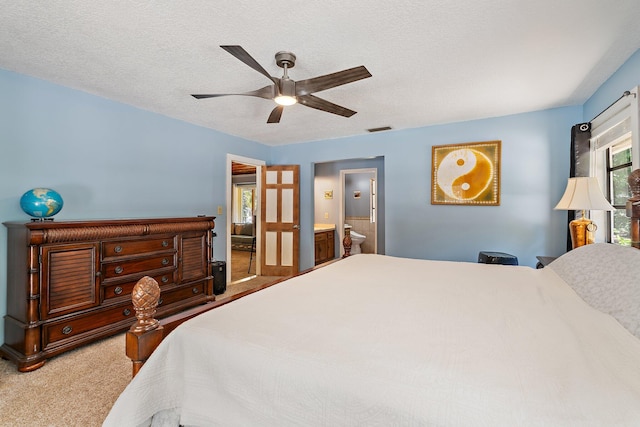 bedroom featuring carpet flooring, a ceiling fan, visible vents, and ensuite bathroom