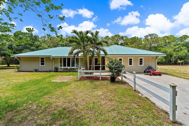 ranch-style house featuring metal roof and a front lawn