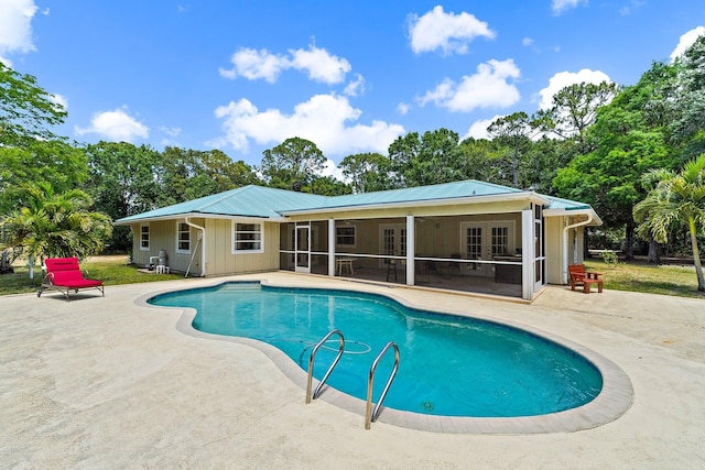 pool with a patio, french doors, and a sunroom