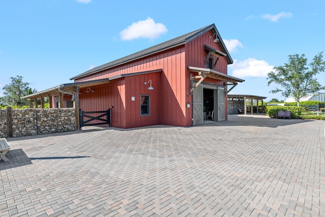 view of outbuilding featuring fence and an outbuilding