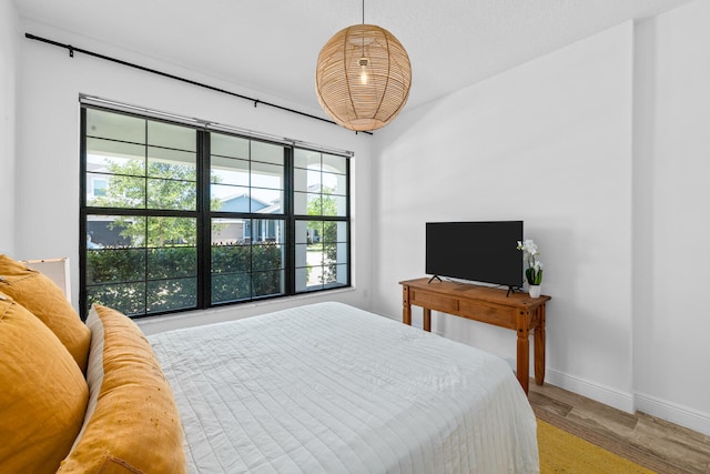 bedroom featuring baseboards and wood finished floors