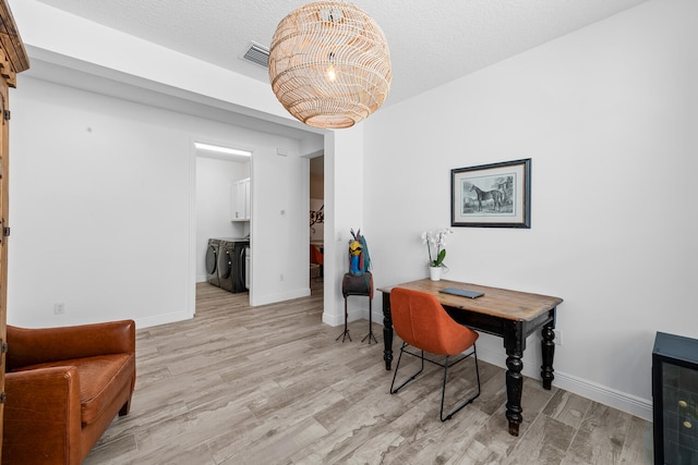 dining room featuring baseboards, visible vents, washer and clothes dryer, and light wood finished floors