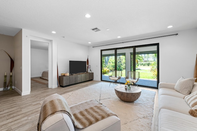 living area featuring visible vents, recessed lighting, light wood-style flooring, and baseboards