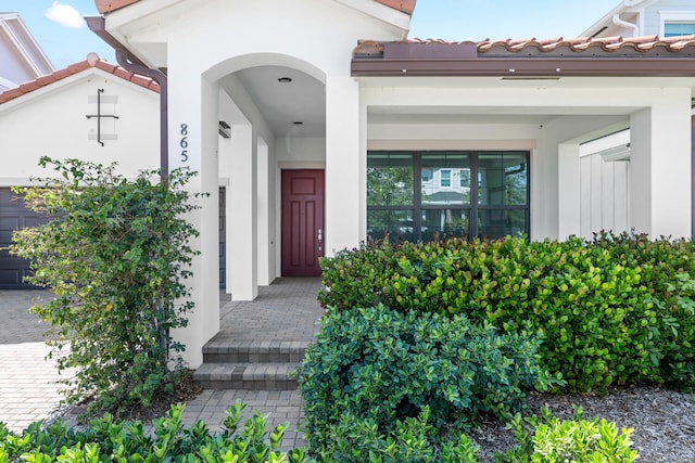 property entrance featuring stucco siding and a tile roof