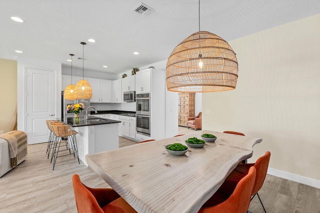 dining area with recessed lighting, baseboards, light wood finished floors, and visible vents