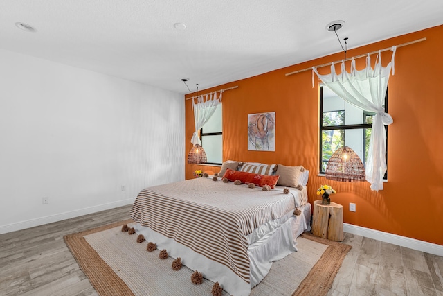 bedroom featuring baseboards and wood finished floors