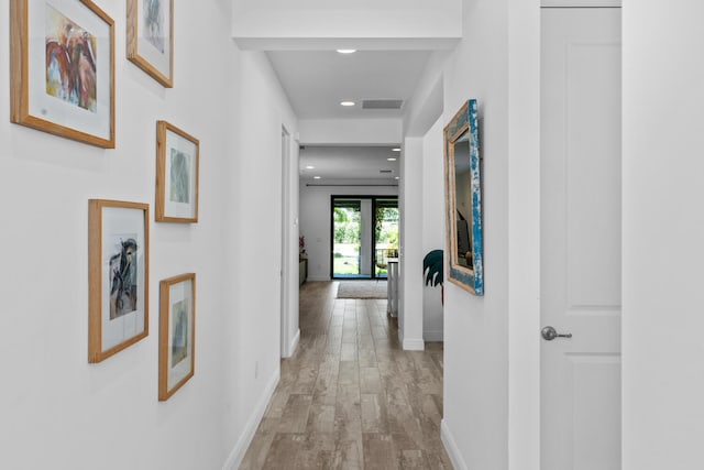 hall featuring visible vents, recessed lighting, baseboards, and light wood finished floors