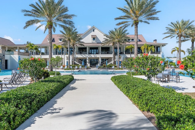 view of property's community with a pool, a patio area, and stairway