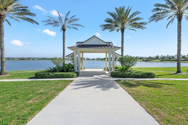 view of property's community with a lawn, a water view, and a gazebo