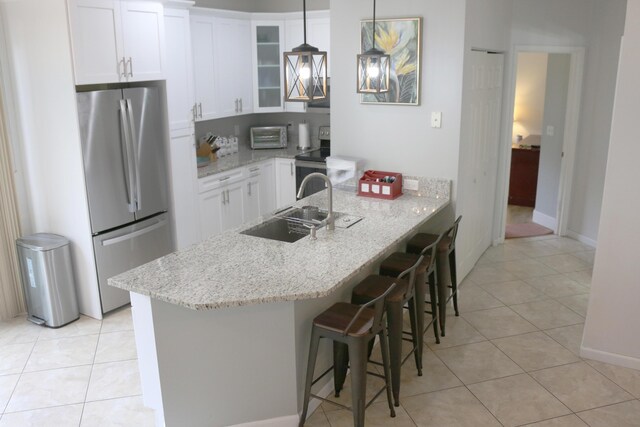 12582 Shoreline Dr, Wellington, FL 33414 - kitchen featuring light tile patterned flooring, appliances with stainless steel finishes, a kitchen breakfast bar, and glass insert cabinets