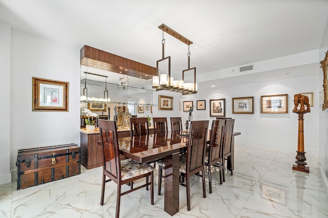 dining space with light marble finish flooring, a chandelier, and baseboards
