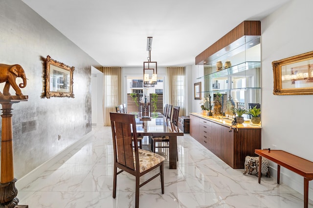 dining room featuring light marble finish flooring and a chandelier
