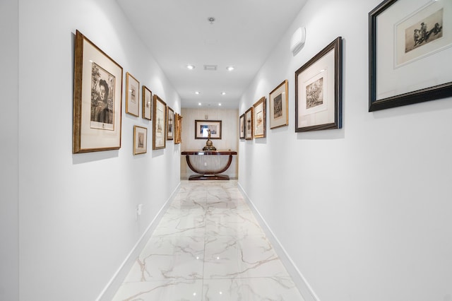 hallway with light marble finish flooring, recessed lighting, and baseboards