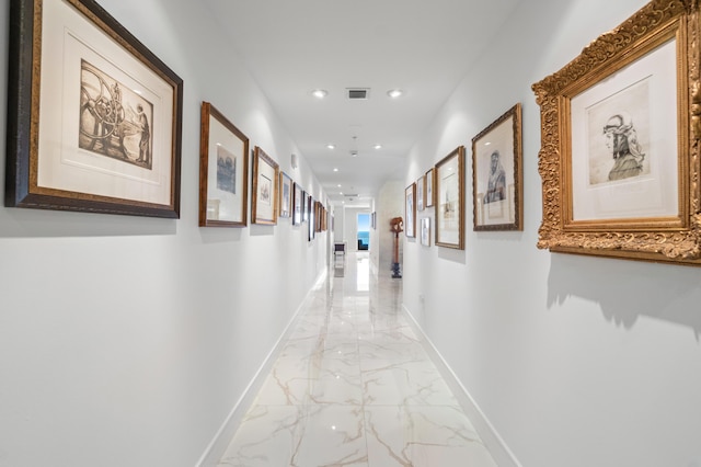 hallway featuring light marble finish flooring, recessed lighting, and baseboards