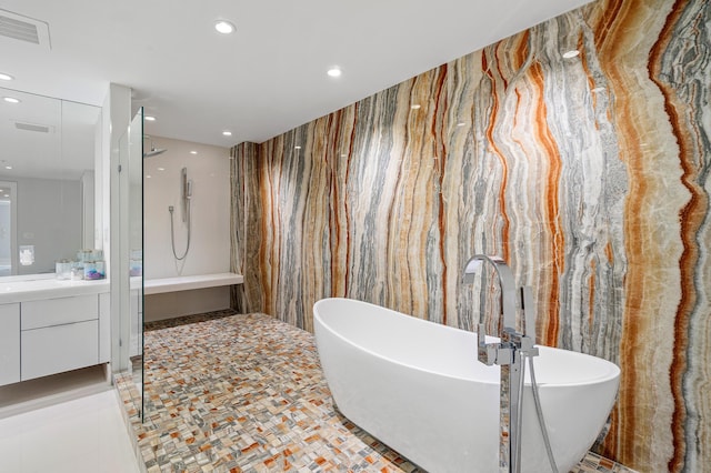 bathroom with recessed lighting, vanity, a soaking tub, and a walk in shower