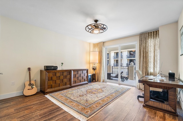 office featuring wood finished floors, a ceiling fan, and baseboards