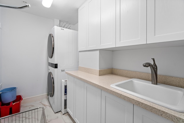 washroom with stacked washer and clothes dryer, a sink, and light marble finish floors