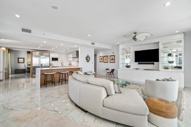 living area with recessed lighting and light marble finish flooring